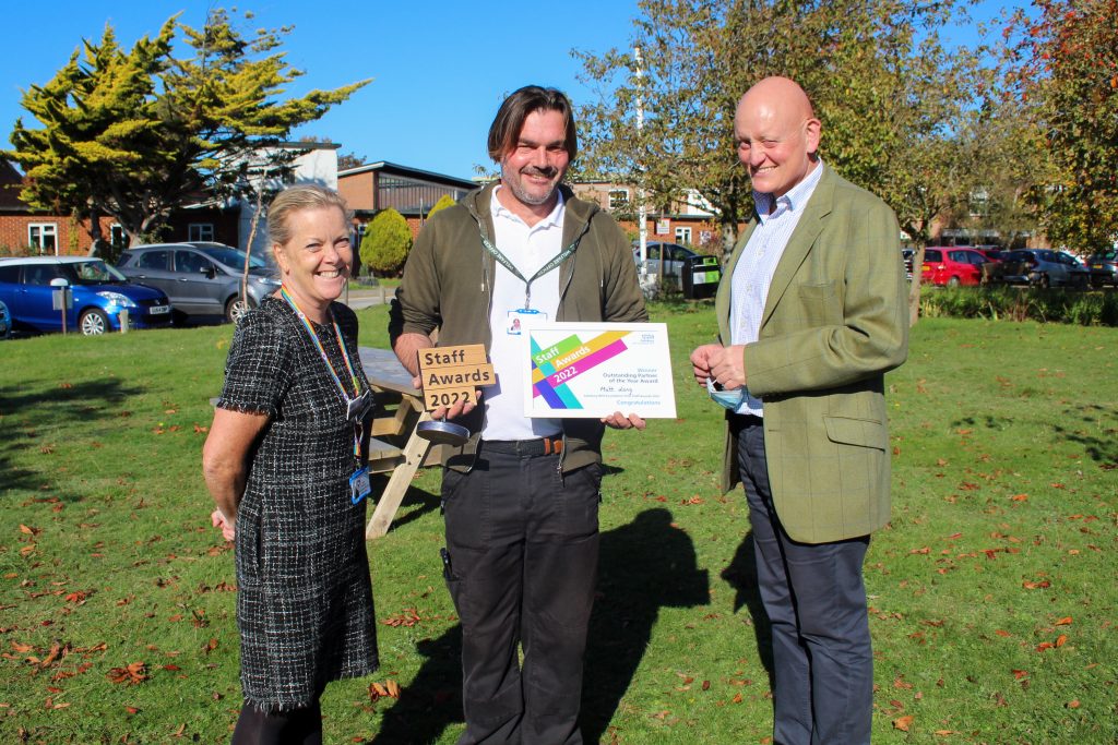 (Left) Jane Dickinson Deputy Chief Operating Officer for Salisbury NHS Foundation Trust, (Centre) Matt Long Welfare Officer for DMWS, (Right) Major General (Ret'd) Tim Hyams, Chief Executive ABF The Soliders' Charity. Matt holding award all three smiling to camera.